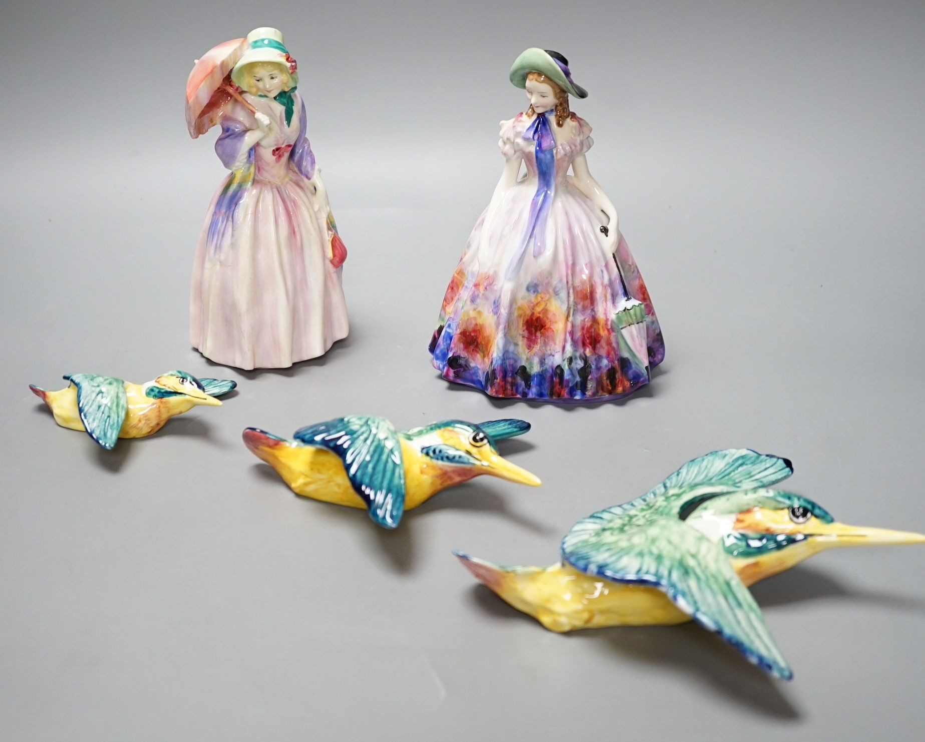 A Royal Doulton figurine: Reg No753474, Miss Demure and an Easter Day figurine: HN 2039, together with three Beswick Kingfisher wall plaques, damage